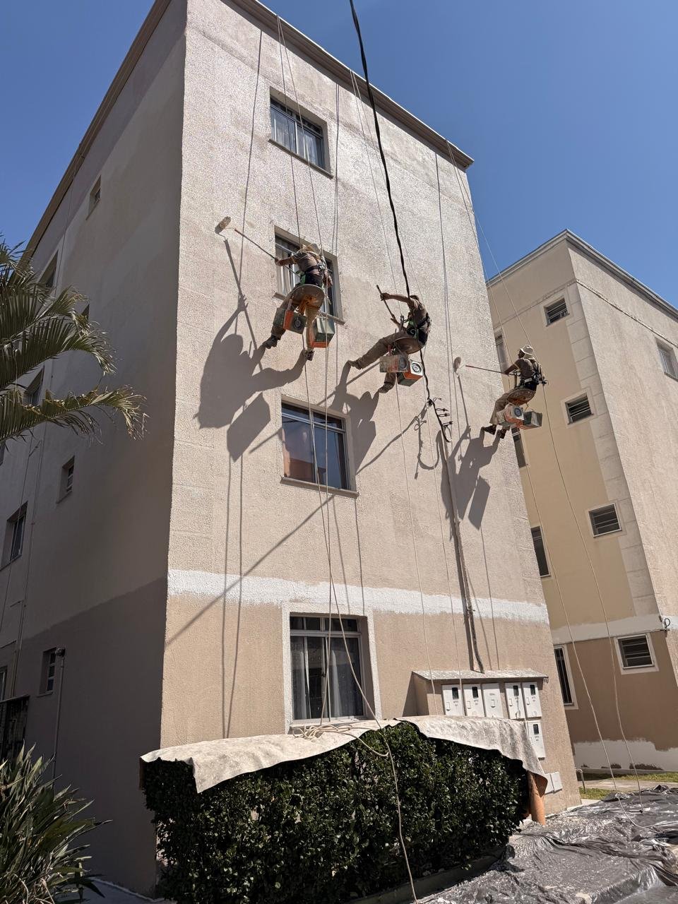 Três profissionais da Província Decor trabalhando simultaneamente em fachada